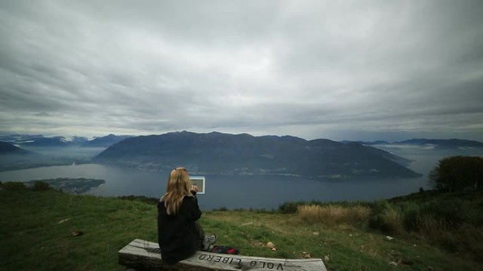 游客坐在长椅上看数字平板电脑上的地图