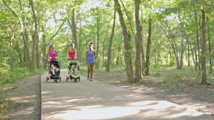 一群妈妈在公园一起锻炼，推着婴儿车