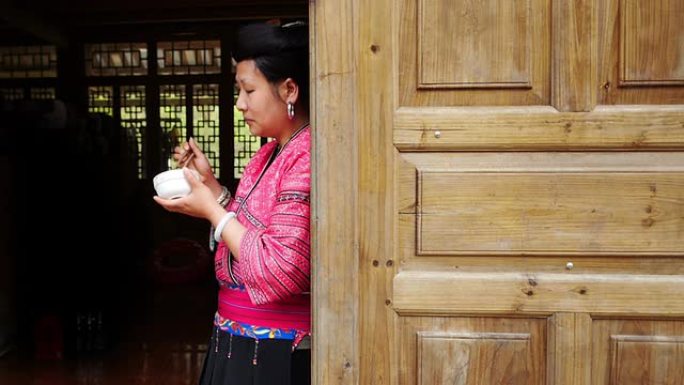 中国女人穿着传统衣服吃米饭