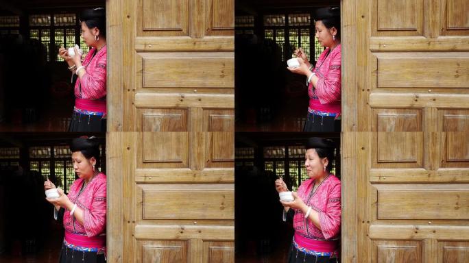 中国女人穿着传统衣服吃米饭