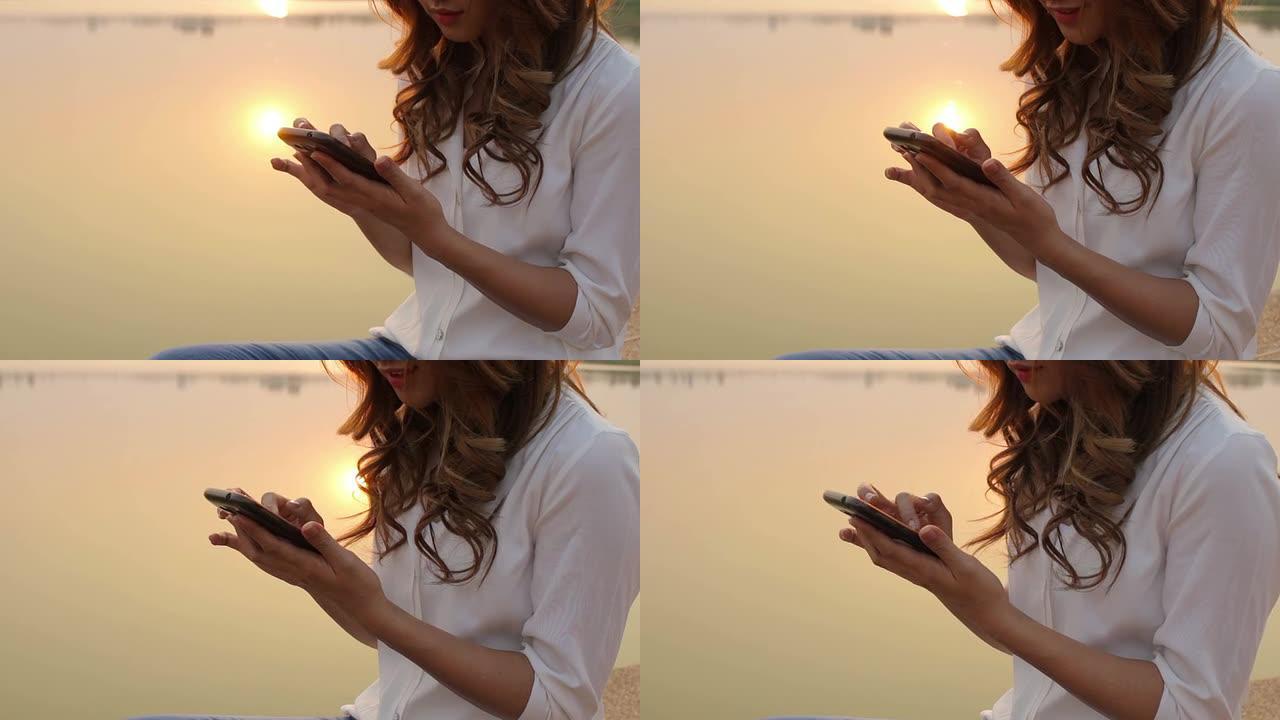 湖边使用智能手机的女孩