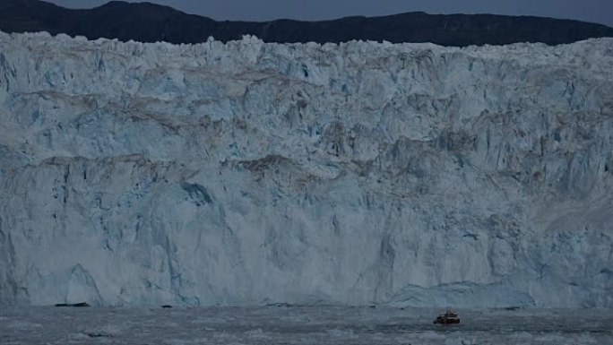 蓝色冰壁前浮冰之间的游船