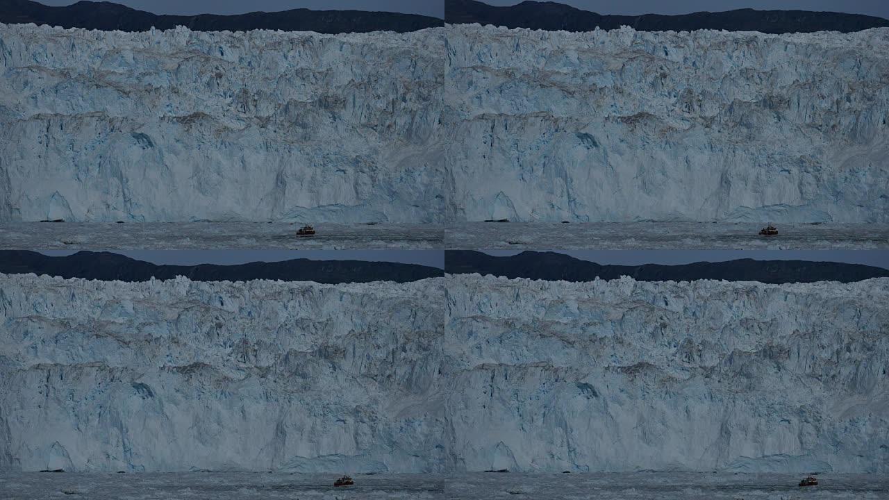蓝色冰壁前浮冰之间的游船