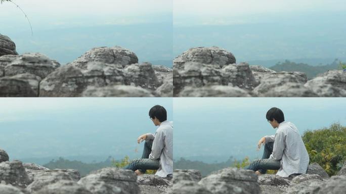 孤独的人坐在悬崖上