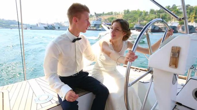 游艇巡游掌舵的新娘和新郎