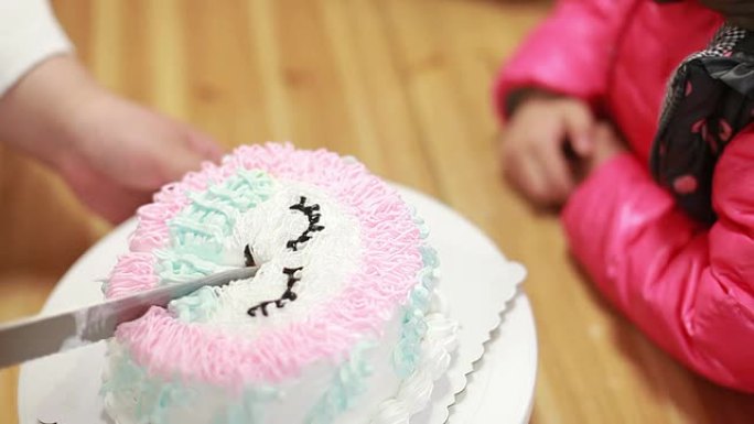 小女孩等待生日蛋糕切成碎片。