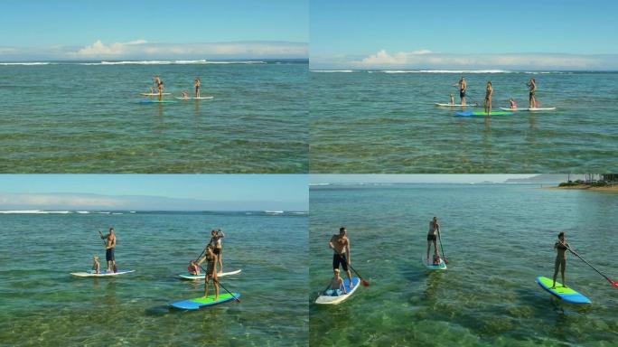 夏威夷热带海滩度假的家庭桨板冲浪