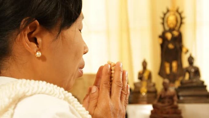 亚洲老妇人在礼拜场所祈祷和冥想