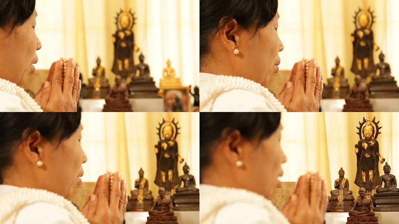 亚洲老妇人在礼拜场所祈祷和冥想