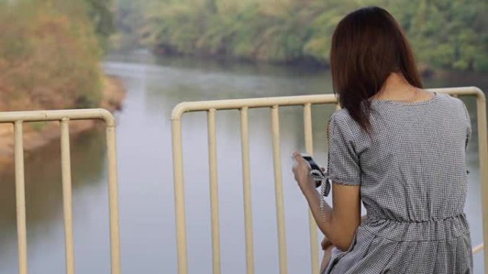 使用智能手机湖景的年轻亚洲女性