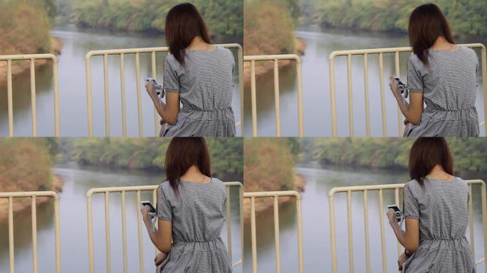 使用智能手机湖景的年轻亚洲女性
