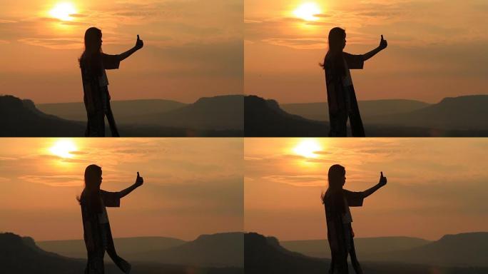 日落时与山自拍的女性剪影。