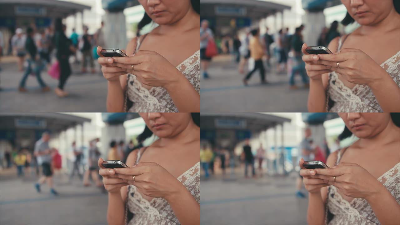 慢镜头：亚洲女性在城市场景中用智能手机阅读信息