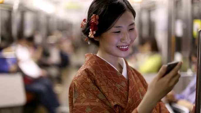 地铁里穿着和服的日本女孩给朋友发短信