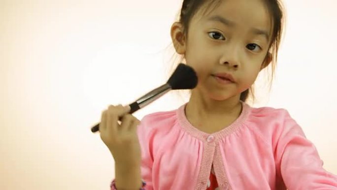 亚洲小女孩用刷子化妆