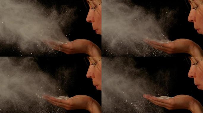 女人从手中吹面粉