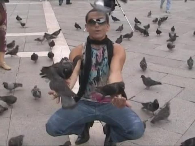 威尼斯圣马可广场有人在喂鸽子