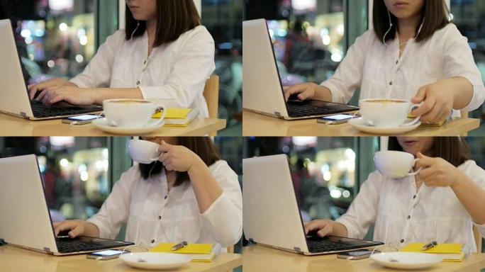 年轻女子在4k(UHD) 夜间在咖啡厅使用笔记本电脑工作