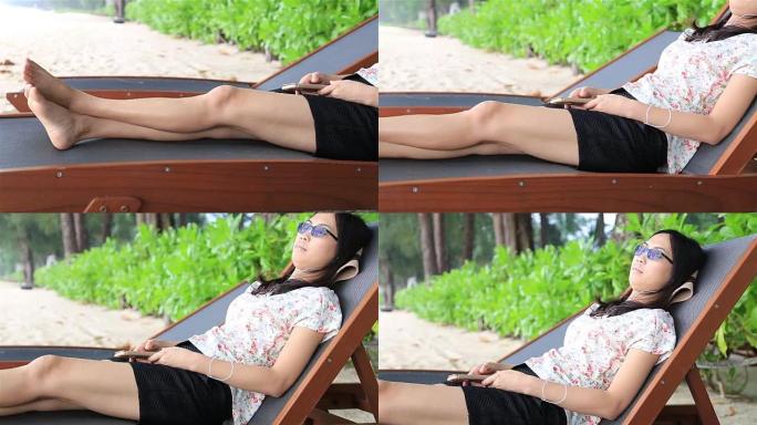 高清多莉: 女人躺在沙滩上的床上听音乐