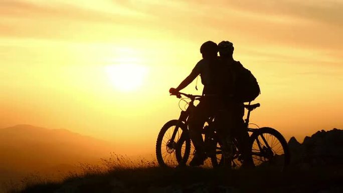 高清起重机: 骑自行车的人在日落时欣赏美景