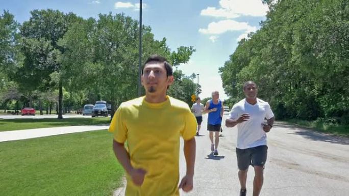 年轻的西班牙裔男子在户外锻炼时带领一群跑步者