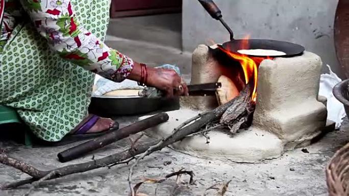 妇女在家在泥炉上做饭