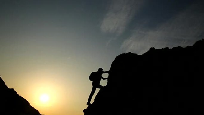 男性登山者在日落时的剪影。