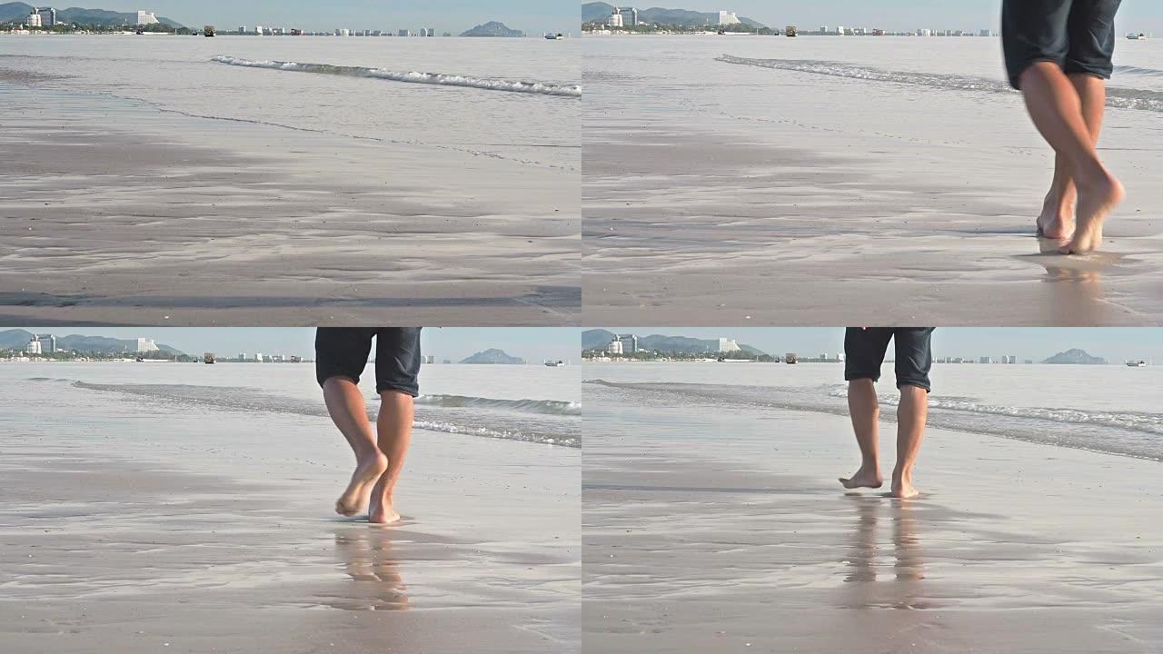 脚在海浪上行走的慢动作，脚印在海边的沙滩上