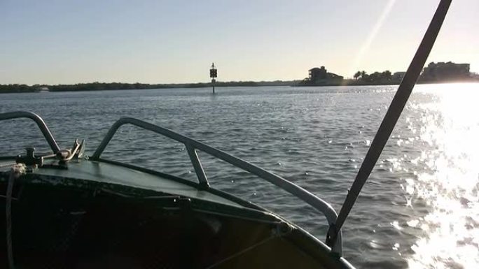 摩托艇的右舷在水中向着日出加速