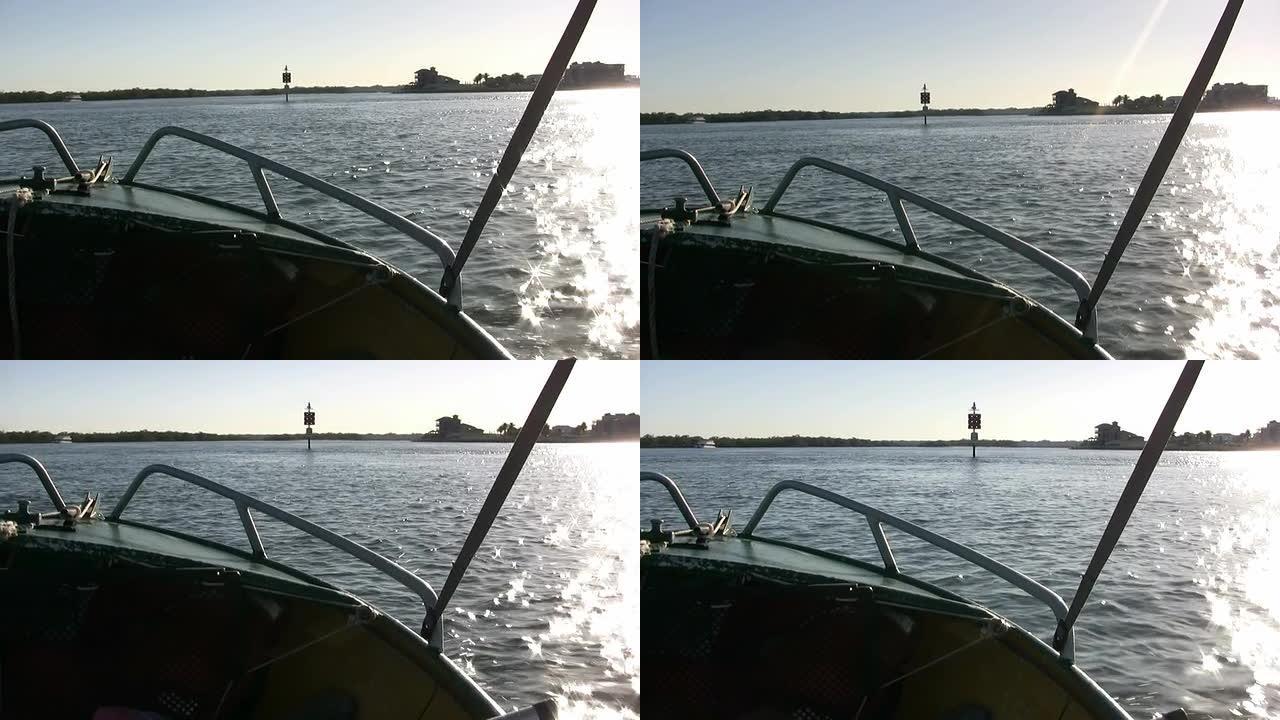 摩托艇的右舷在水中向着日出加速