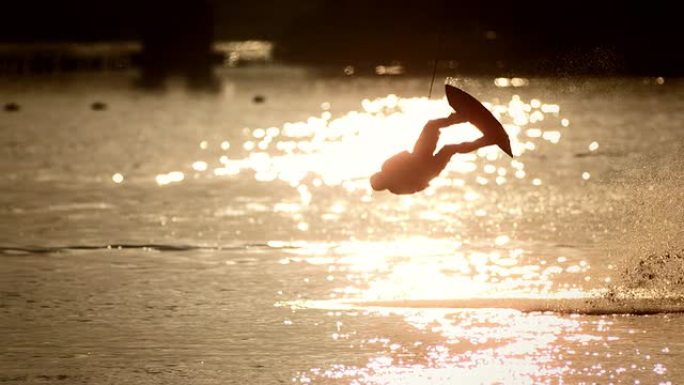 高清超慢动作: 滑水运动员在日落时表演跳跃技巧
