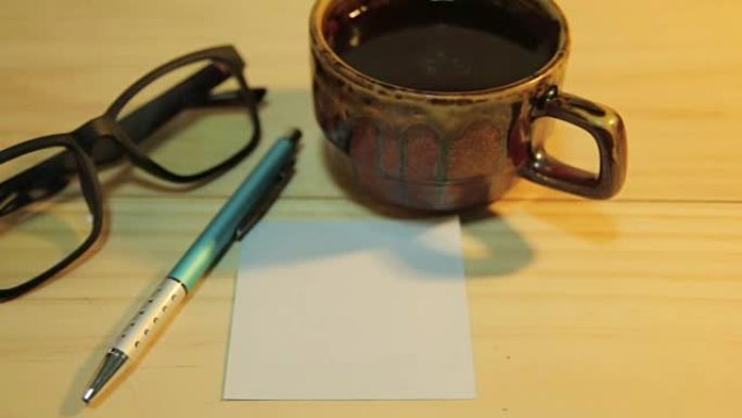 多莉相机拍摄: 白纸和一杯咖啡，钢笔和眼镜。