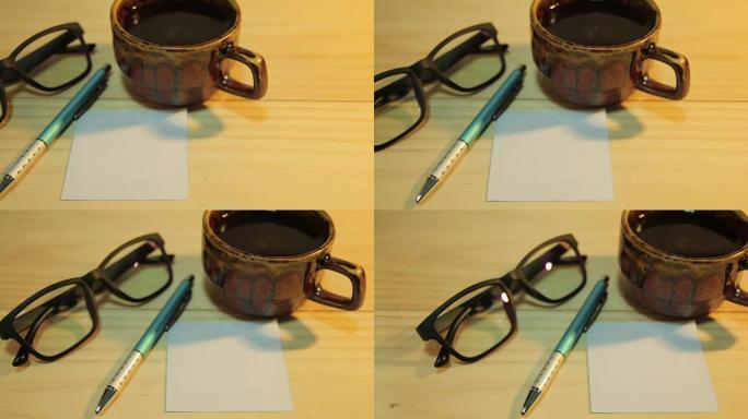 多莉相机拍摄: 白纸和一杯咖啡，钢笔和眼镜。