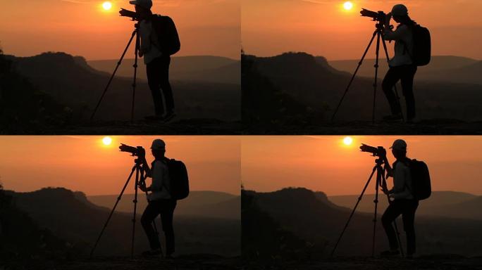 女人的剪影在日落时与山合影。