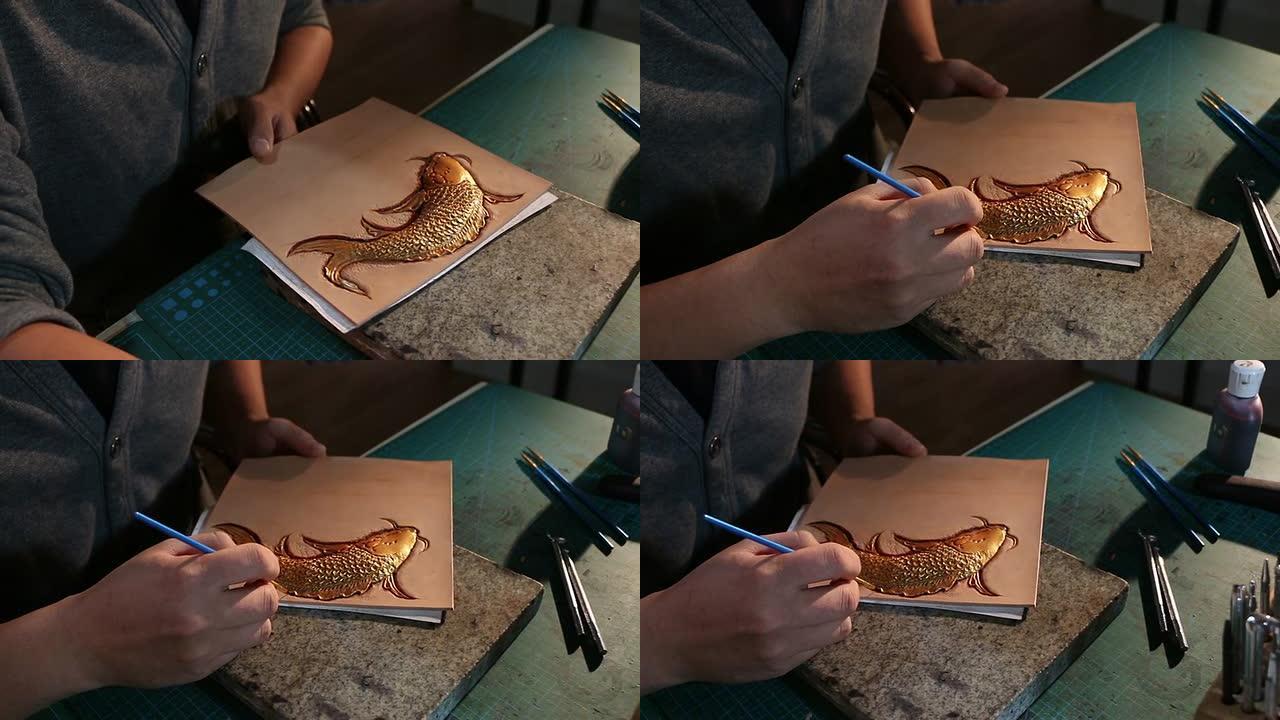 皮革工人在皮革上绘制鱼图案