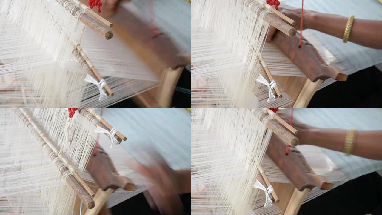 女人在手工织布机中以传统方式编织丝绸。泰国