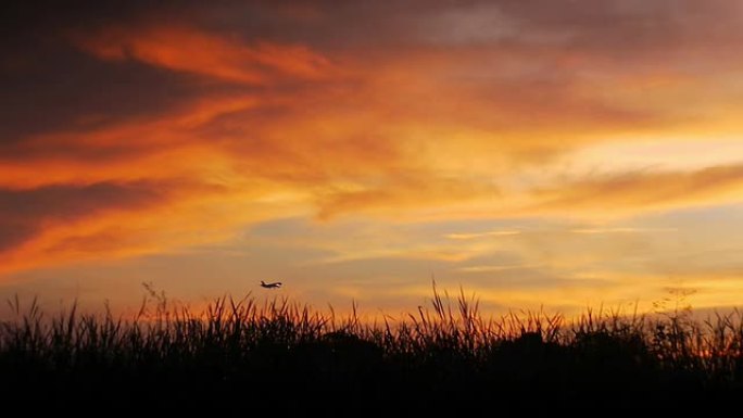 喷气式飞机在日落背景下降落。