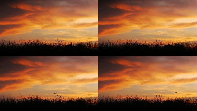 喷气式飞机在日落背景下降落。