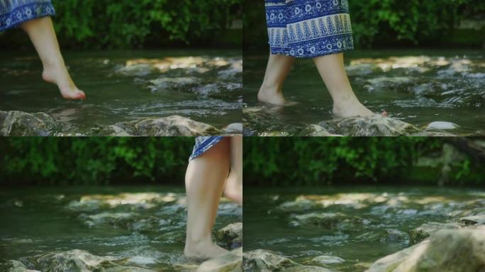 女人赤脚经过水泉摸着石头过河休闲娱乐享受