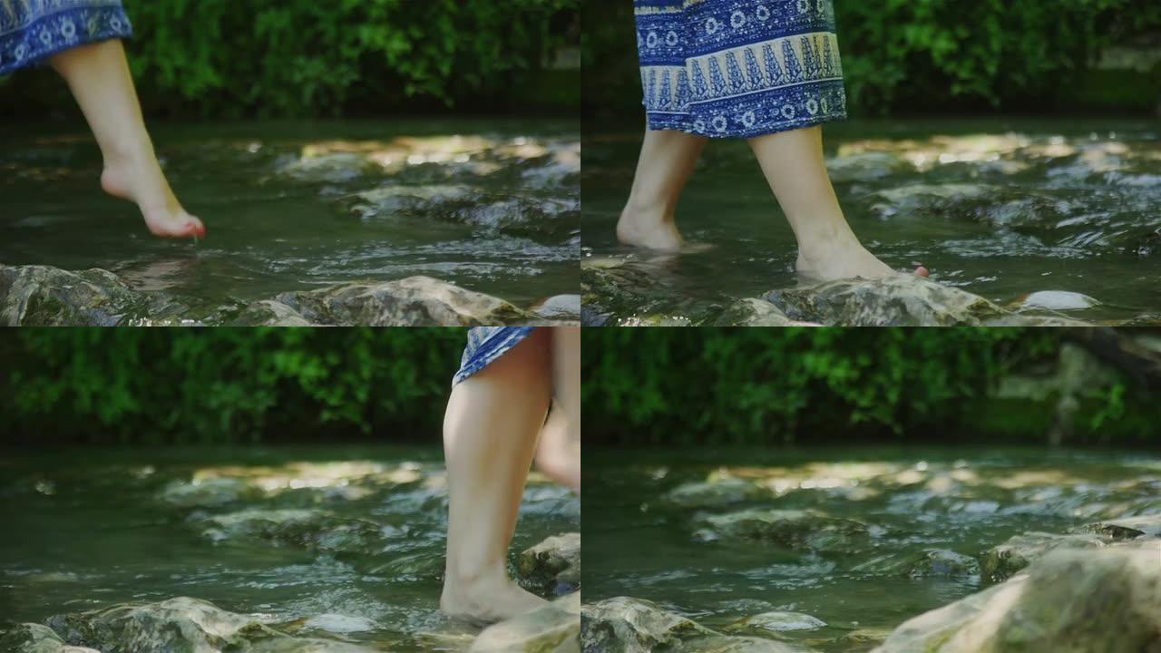 女人赤脚经过水泉摸着石头过河休闲娱乐享受