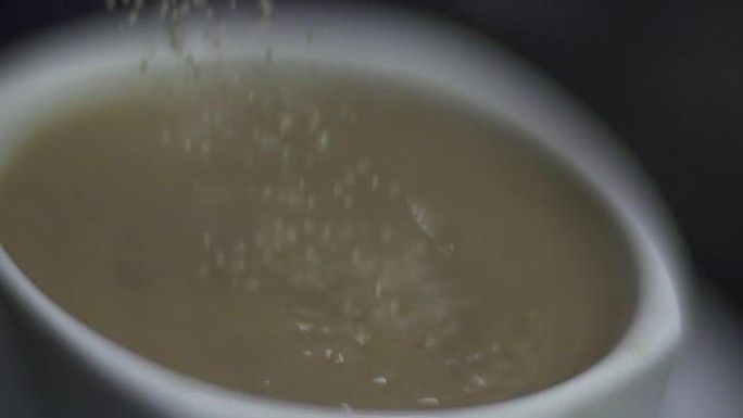 SLO MO特写选择性聚焦糖倒入咖啡中