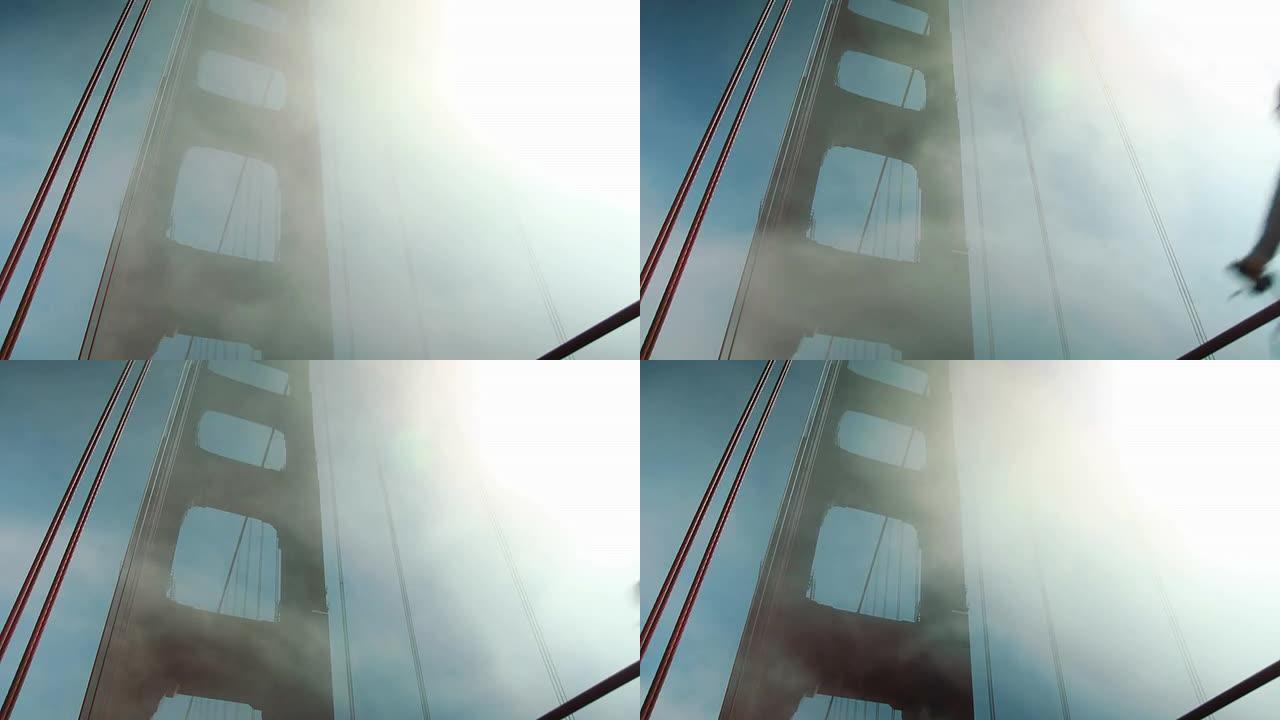当雾飞过去时，骑自行车的人经过金门大桥。