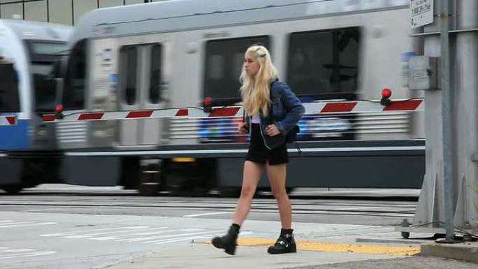 火车经过时，一名十几岁的女孩穿过街道