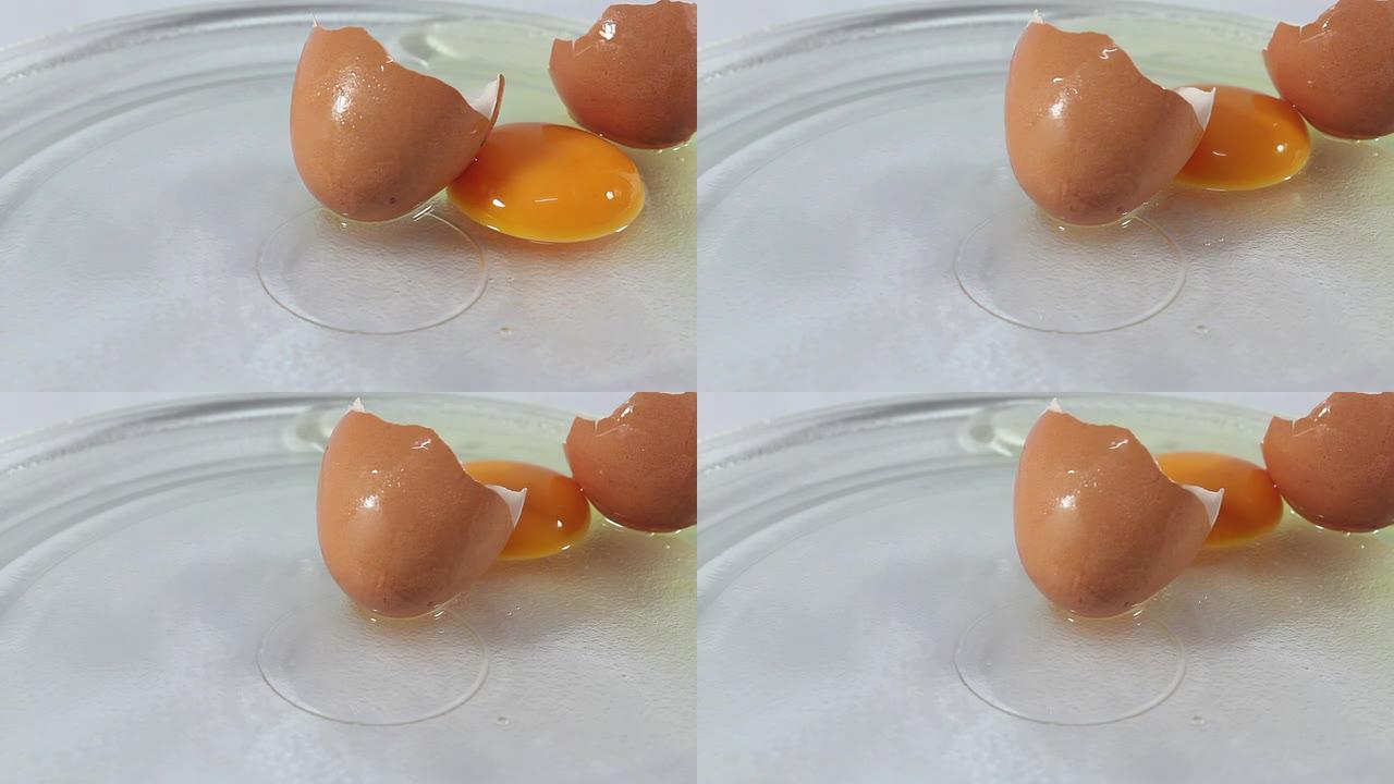 ﻿鸡蛋裂开了。磕开的鸡蛋盘子里的生鸡蛋