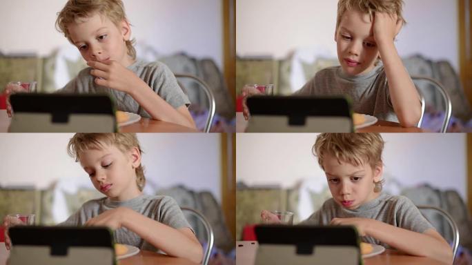 男孩吃饭时在笔记本电脑上玩耍，特写