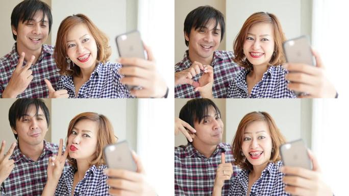 4K: 微笑的情侣在手机上自拍。