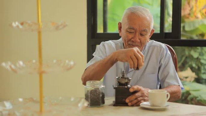 亚洲高级男子，带老式咖啡研磨机
