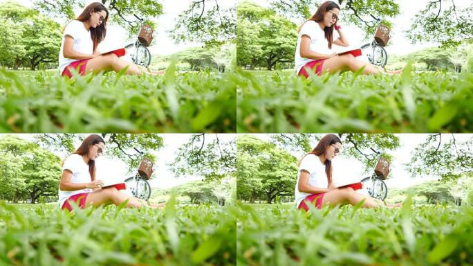 年轻女子坐在公园看书