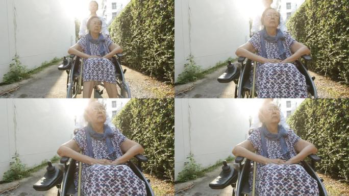 年轻的看护人照顾坐在轮椅上的老年妇女