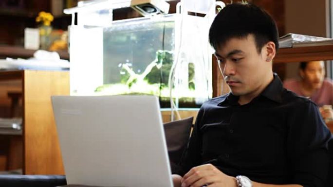 年轻人在咖啡馆相机运动中使用笔记本电脑